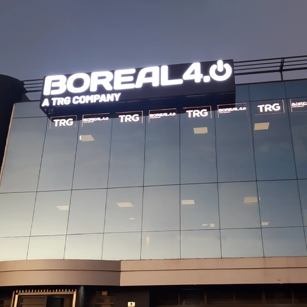 Pantalla transparente Multiled mesh en edificio corporativo visible desde autopista nocturna